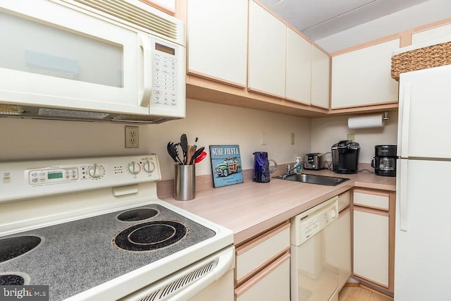 kitchen featuring white cabinets, white appliances, and sink