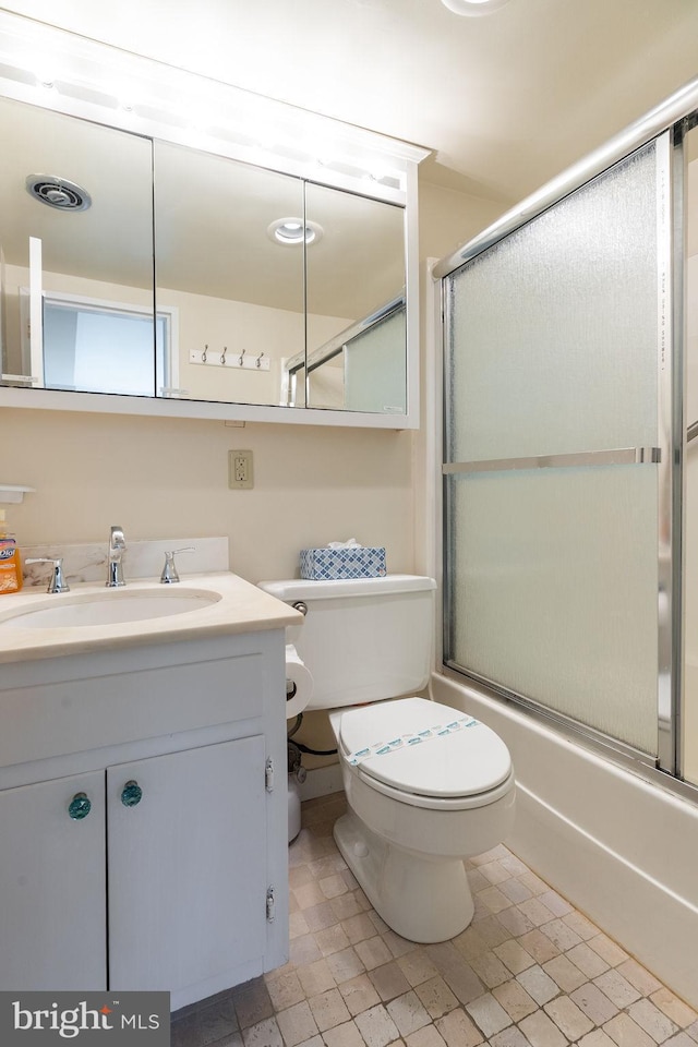 full bathroom with shower / bath combination with glass door, vanity, and toilet