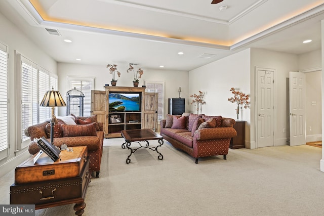 carpeted living room featuring ceiling fan and a tray ceiling