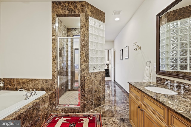 bathroom with vanity and separate shower and tub