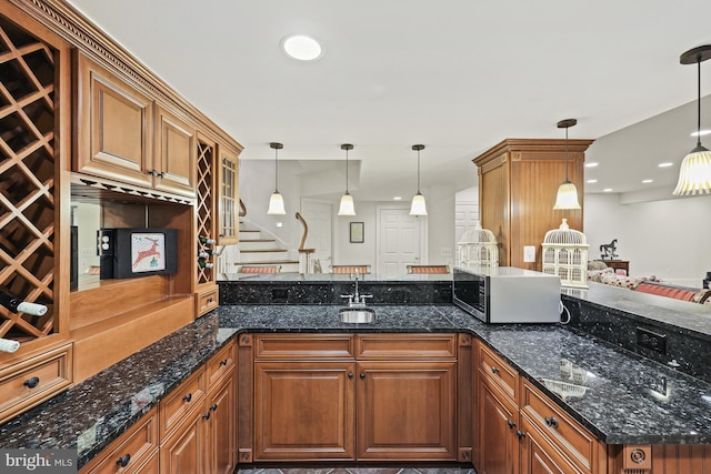 kitchen featuring decorative light fixtures and dark stone counters