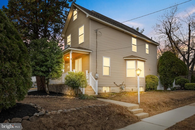 property exterior at dusk featuring a porch