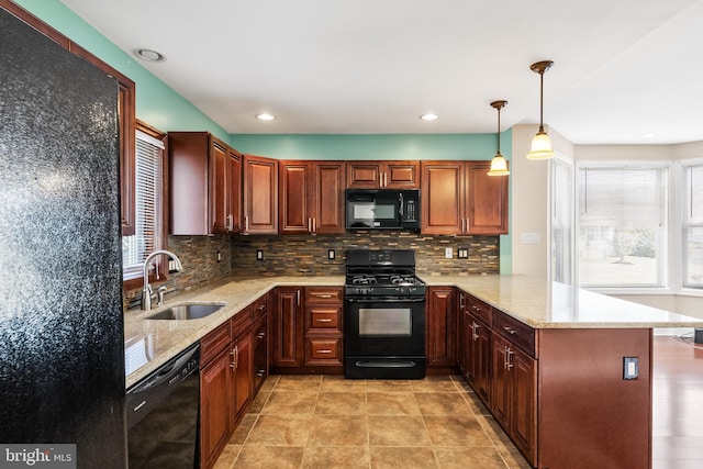 kitchen featuring kitchen peninsula, backsplash, decorative light fixtures, black appliances, and sink