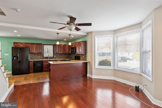 kitchen featuring ceiling fan, tasteful backsplash, decorative light fixtures, dark hardwood / wood-style flooring, and black appliances