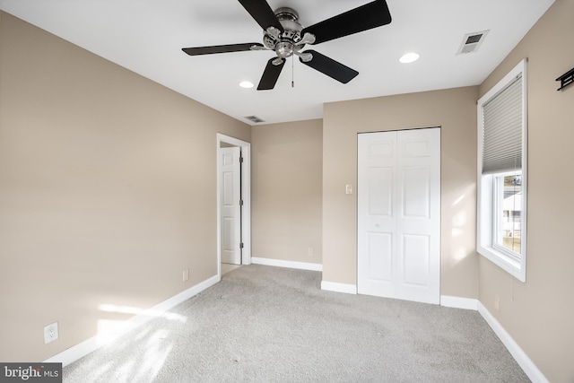 unfurnished bedroom with ceiling fan, light colored carpet, and a closet