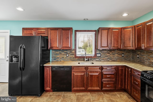 kitchen with light stone countertops, decorative backsplash, sink, and black appliances