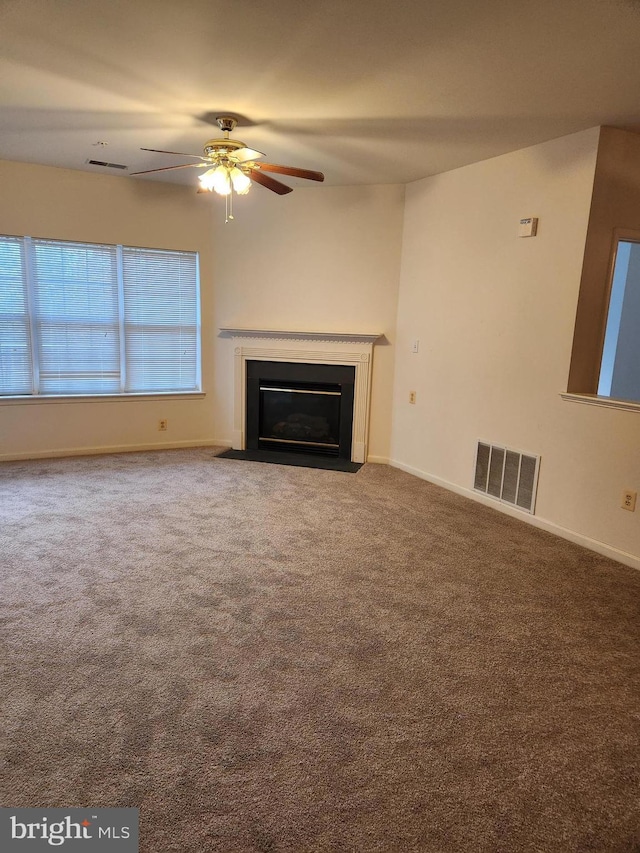 unfurnished living room with ceiling fan and carpet flooring