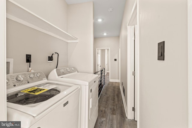 clothes washing area with washer and dryer and dark hardwood / wood-style flooring