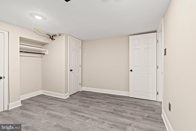 unfurnished bedroom with light wood-type flooring and a closet