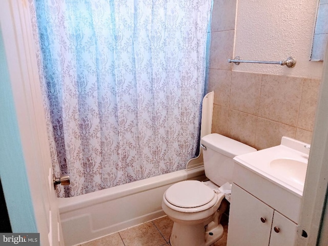 bathroom with tile patterned flooring, vanity, tile walls, and toilet