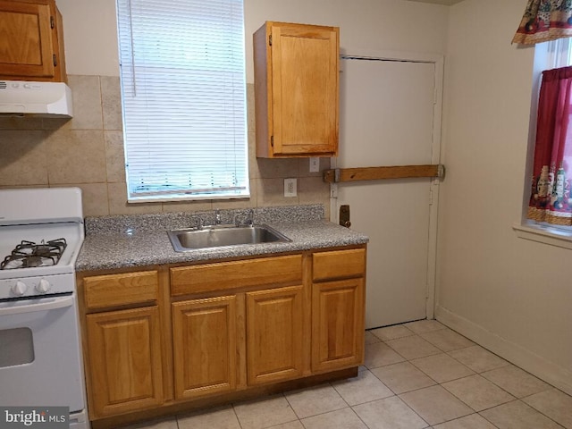 kitchen with decorative backsplash, gas range gas stove, extractor fan, sink, and light tile patterned flooring