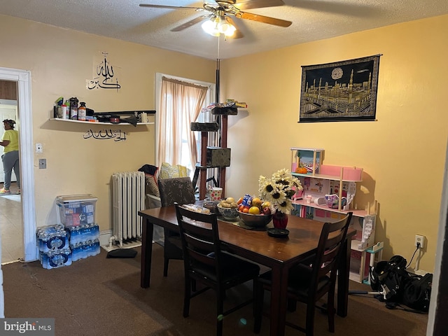 dining area featuring ceiling fan, radiator heating unit, and a textured ceiling