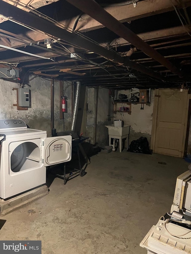 basement with electric panel and washer / clothes dryer