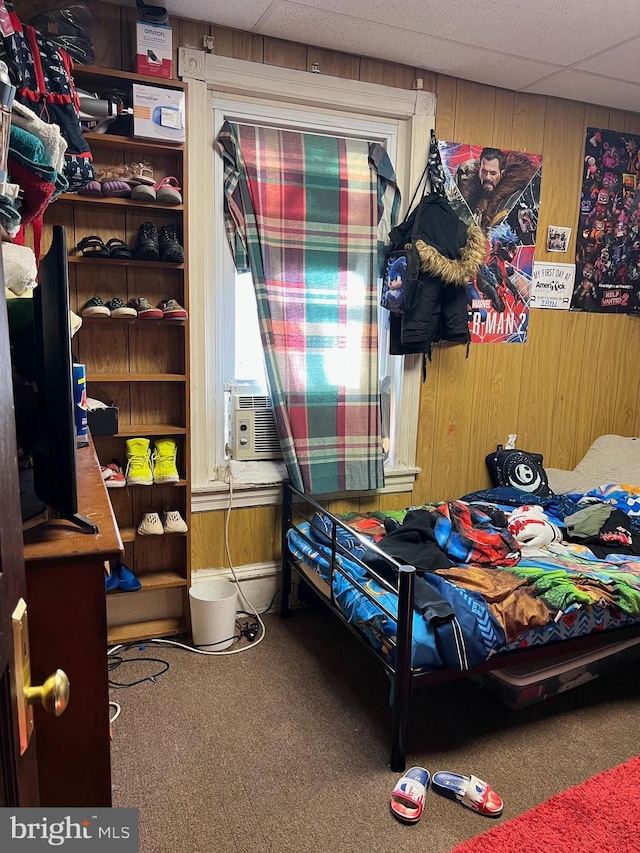 bedroom featuring carpet floors, a paneled ceiling, wooden walls, and cooling unit