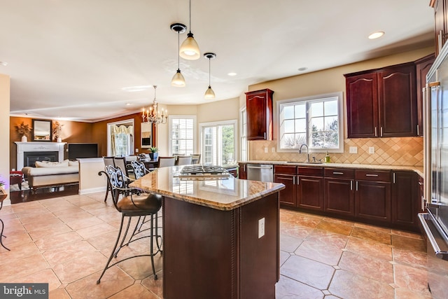 kitchen featuring hanging light fixtures, an inviting chandelier, a kitchen breakfast bar, tasteful backsplash, and a kitchen island