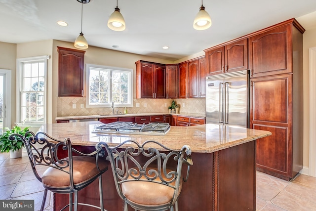 kitchen with plenty of natural light, sink, stainless steel appliances, and hanging light fixtures