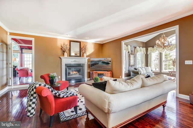 living room featuring hardwood / wood-style flooring, an inviting chandelier, and crown molding