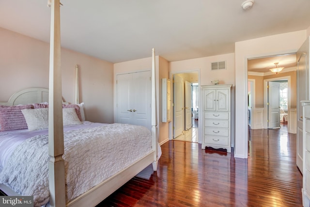 bedroom featuring hardwood / wood-style floors, crown molding, and a closet