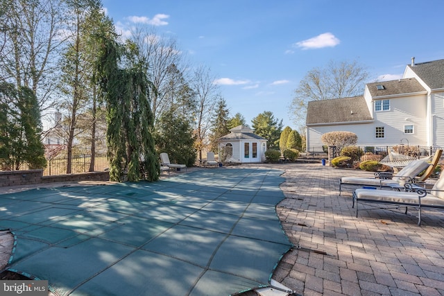 view of pool featuring an outbuilding and a patio