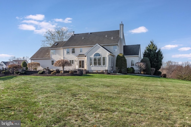 rear view of house featuring a lawn