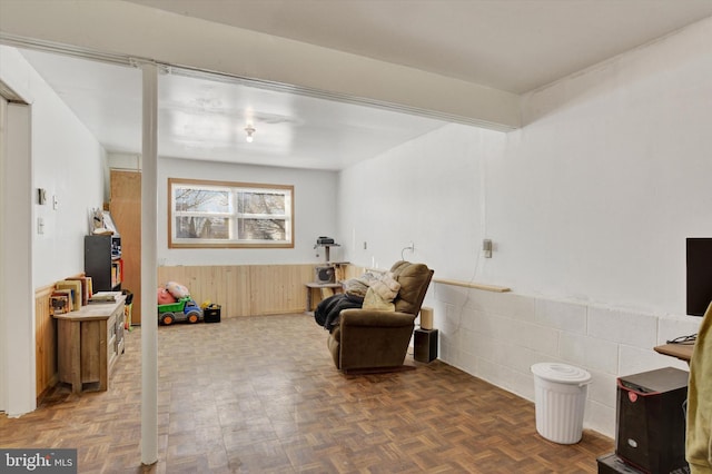 sitting room featuring dark parquet flooring and tile walls