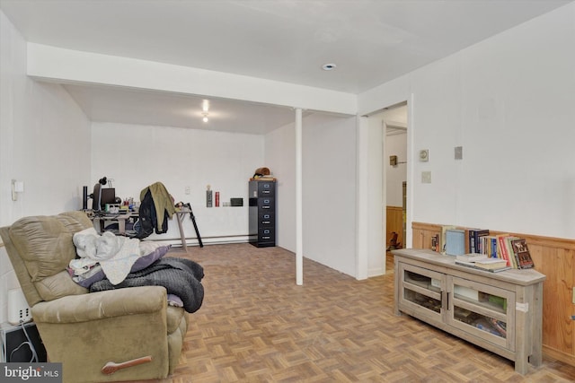 living area with light parquet flooring and a baseboard heating unit