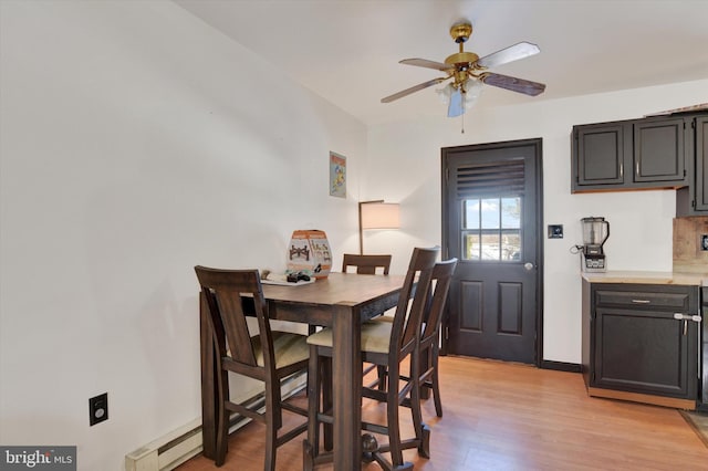 dining area with ceiling fan, a baseboard heating unit, and light hardwood / wood-style flooring