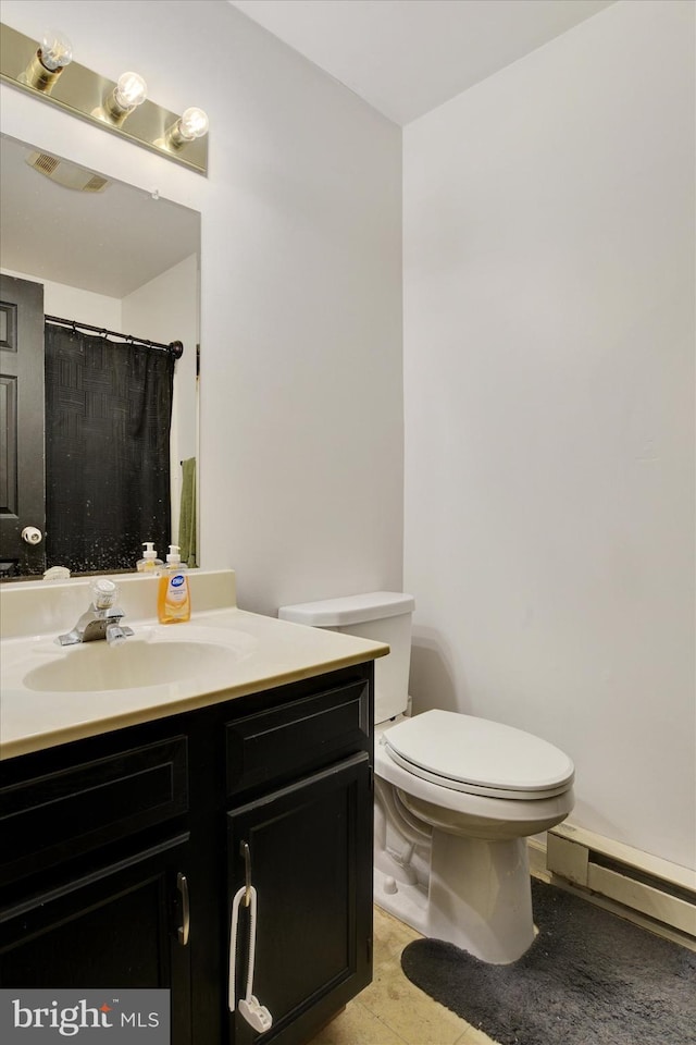 bathroom featuring tile patterned floors, vanity, toilet, and a baseboard heating unit