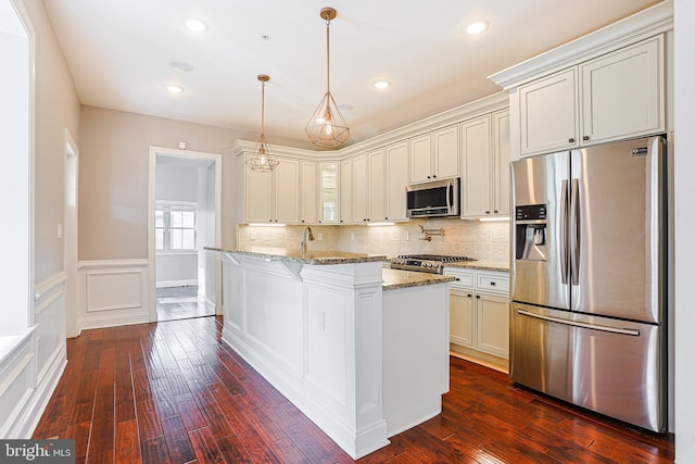 kitchen with stainless steel appliances, tasteful backsplash, light stone counters, and decorative light fixtures