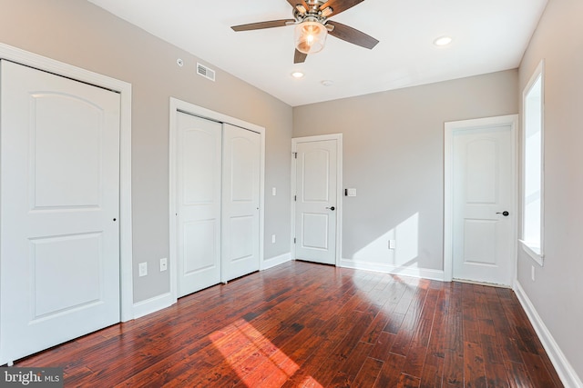 unfurnished bedroom featuring dark wood-type flooring, ceiling fan, and a closet