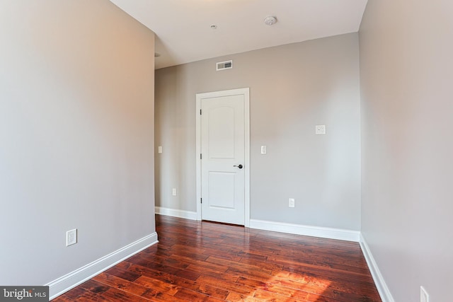 unfurnished room with dark hardwood / wood-style flooring