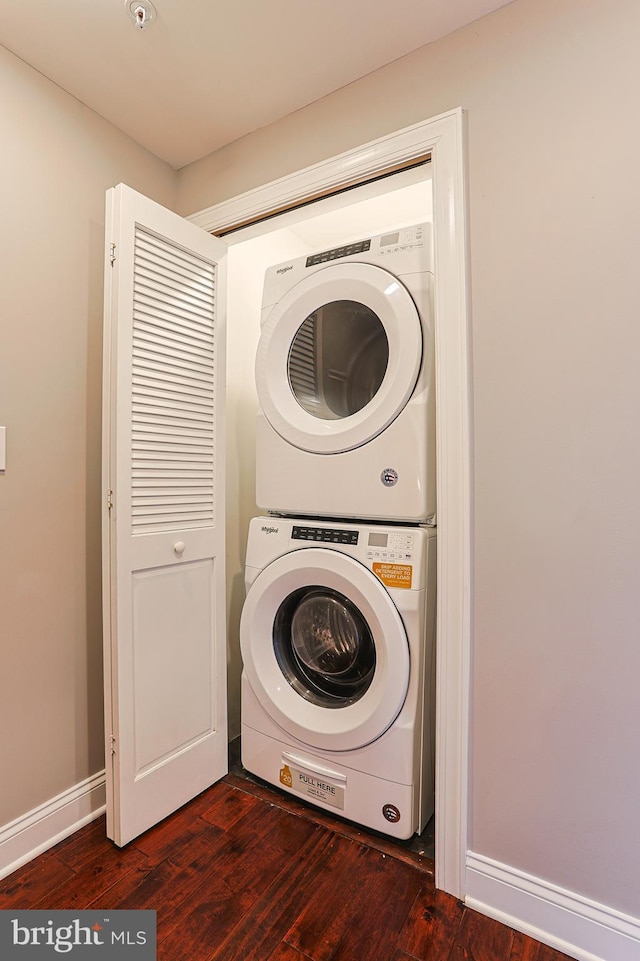 clothes washing area with dark wood-type flooring and stacked washing maching and dryer