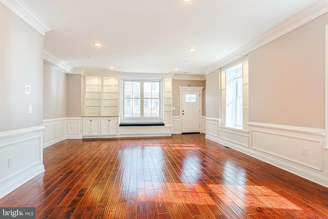 unfurnished living room with built in features, plenty of natural light, ornamental molding, and dark hardwood / wood-style floors