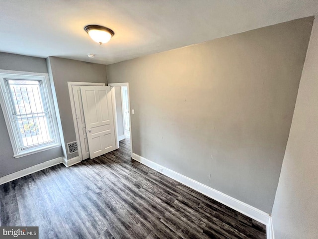 unfurnished bedroom with dark hardwood / wood-style flooring and a closet