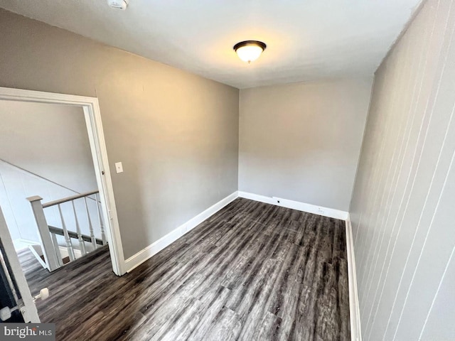 unfurnished room with dark hardwood / wood-style flooring