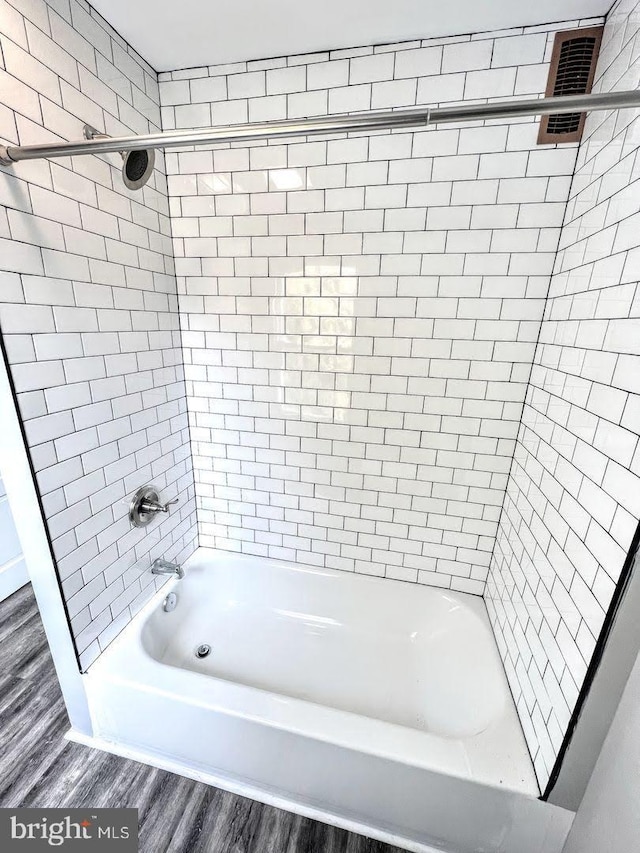 bathroom featuring hardwood / wood-style flooring and tiled shower / bath