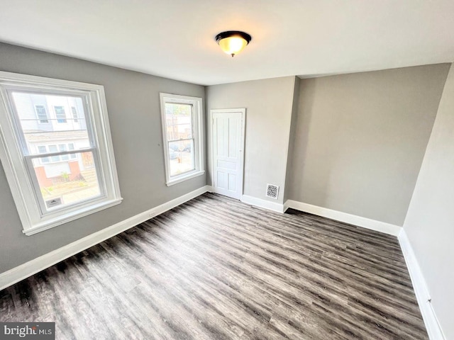 unfurnished bedroom with dark wood-type flooring and a closet