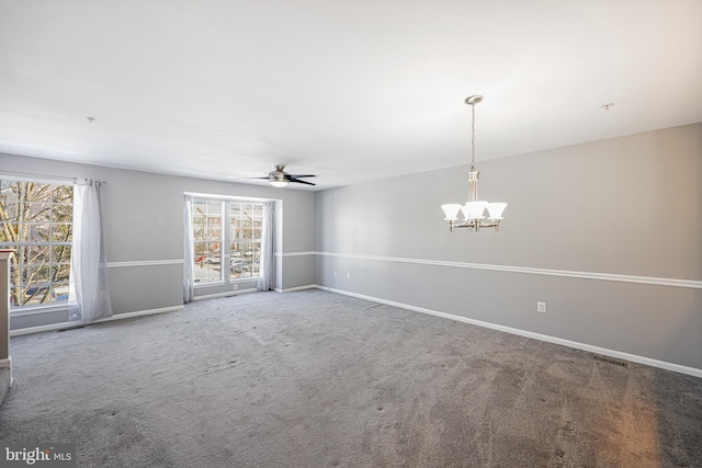 carpeted spare room with ceiling fan with notable chandelier