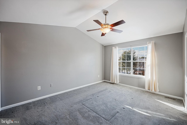 carpeted spare room featuring ceiling fan and lofted ceiling