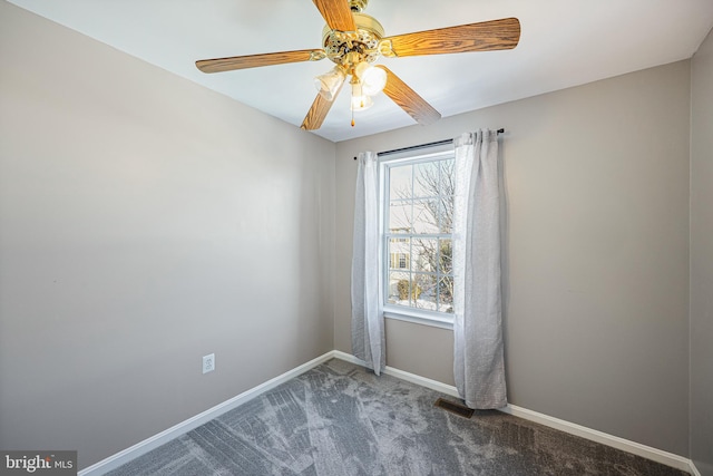 carpeted spare room featuring ceiling fan