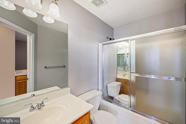 full bathroom featuring toilet, combined bath / shower with glass door, and vanity