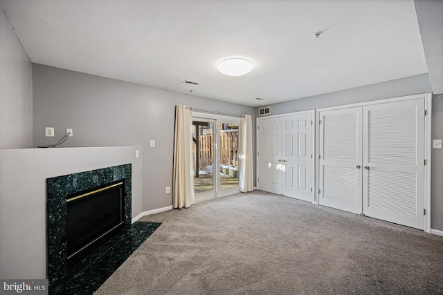 unfurnished living room with carpet flooring and a premium fireplace