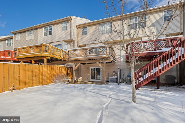 snow covered property with central air condition unit