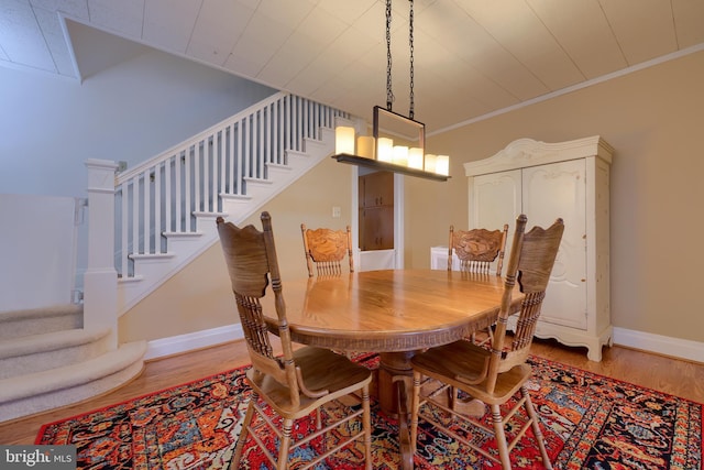 dining space with hardwood / wood-style floors and crown molding