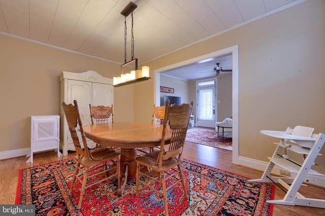 dining room featuring hardwood / wood-style floors, ceiling fan, and crown molding