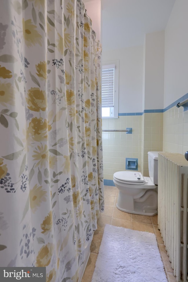 bathroom with radiator, tile patterned floors, toilet, tile walls, and a shower with shower curtain