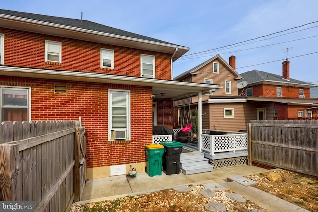 rear view of property featuring cooling unit and a deck