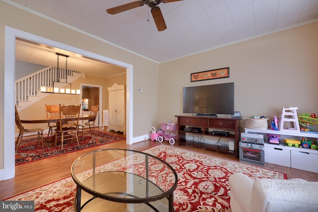 living room with hardwood / wood-style flooring, ceiling fan, and crown molding