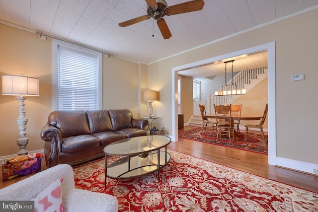 living room with ceiling fan, wood-type flooring, and ornamental molding