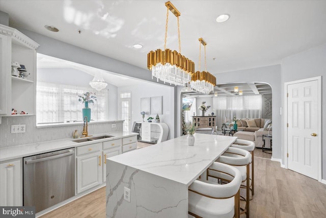 kitchen with dishwasher, a center island, sink, hanging light fixtures, and white cabinetry